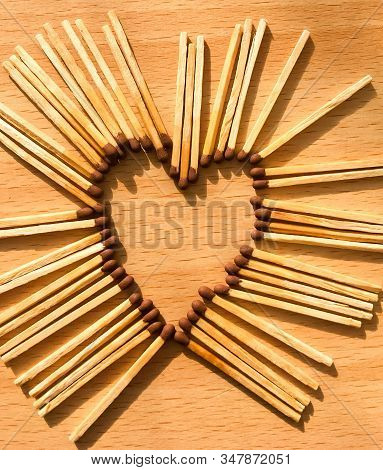 Wooden Safety Matches On A Wooden Background Arranged In The Shape Of A Heart. Matchsticks In The Sh