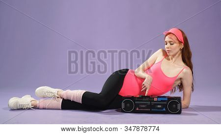 Red-haired Fitness Woman With Freckles Listens To Music On The Floor On A Portable Audio Player,