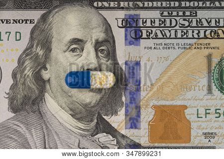 Drugs Pill On The Ben Franklin's Mouth Of Hundred-dollar Bill. High Cost Of Drugs Concept