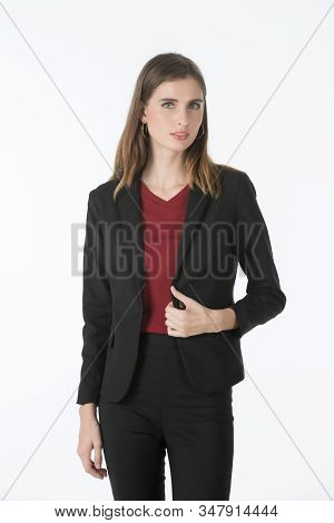 Young Blonde Caucasian Businesswoman In A Suit Smiles Shyly And Plays With Her Hair. She Is Happy To