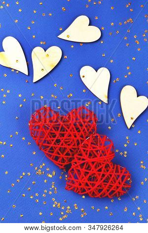 Beautiful Red And Wooden Hearts On The Cornflowerblue Background In The Golden Star Sequins. St Vale