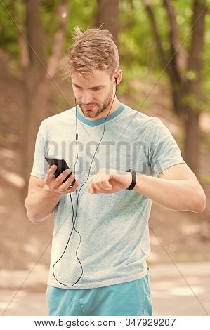 Monitoring And Boosting His Training. Sportsman Tracking His Training With Fitbit And Smartphone. Fi