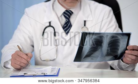Pulmonologist Looking At Lung X-ray Prescribing Treatment To Patient, Healthcare