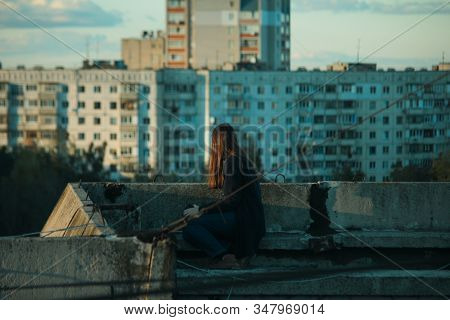 Girl Sitting On The Edge Of The Roof And Afraid Of Heights