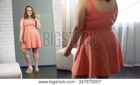 Plump Girl Crying, Holding Donuts In Front Of Mirror Unhappy With Her Appearance