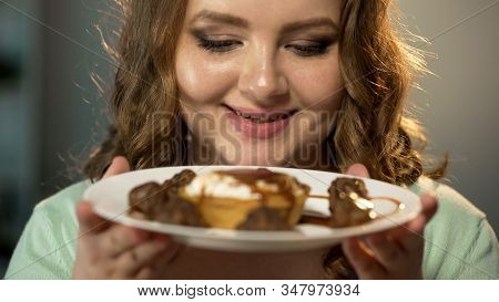 Obese Lady Looks With Hungry Eyes At Sweets Under Chocolate Dressing, Overweight
