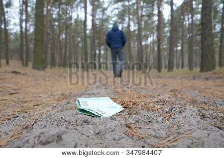 Young Man Loses His Euro Money Bills On Russian Autumn Fir Wood Path. Carelessness And Losing Money 