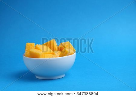 White Bowl Of Mango Succades Isolated On Blue Background. Image Contains Copy Space