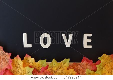 Love Day Concept. The Wooden Text Remain To Valentine's Day With Maple Leaf And Black Background.val