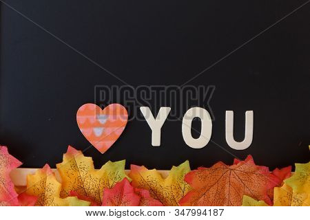Love Day Concept. The Wooden Text Remain To Valentine's Day With Maple Leaf And Black Background.val