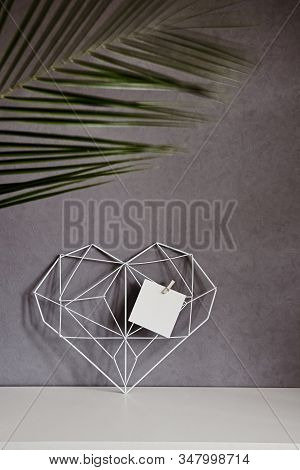 Graceful Openwork Heart With Notes On A Concrete Wall Background. Minimalism. Concept Symbol Of Love
