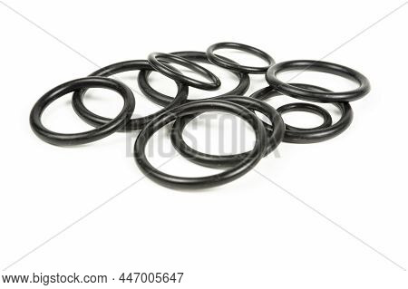 Hydraulic And Pneumatic O-rings In Black In Different Sizes On A White Background. Various Seals For
