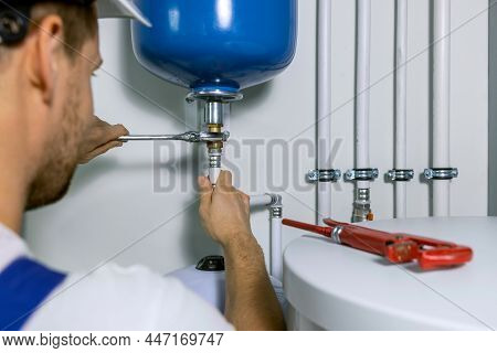 Plumber Installing Expansion Tank For House Heating System. Plumbing Service