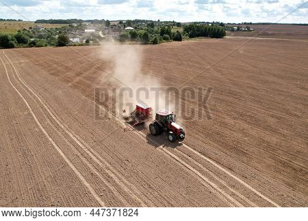 Tractor Sowing Seed Onto At Field. Planting Equipment And Farm Implements And Machine. Mini Agricult