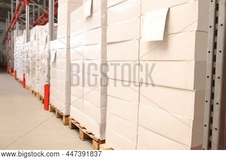 Warehouse With Stacks Of Boxes On Wooden Pallets. Wholesaling