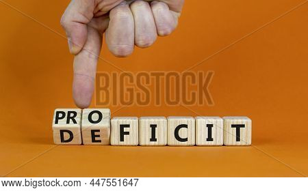 Proficit Or Deficit Symbol. Businessman Turns Cubes, Changes The Word Deficit To Proficit. Beautiful