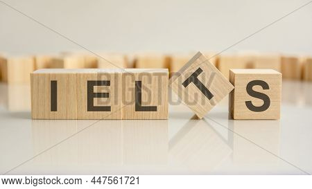 Ielts - Word Of Wooden Blocks With Letters On A Gray Background. Reflection Of The Caption On The Mi