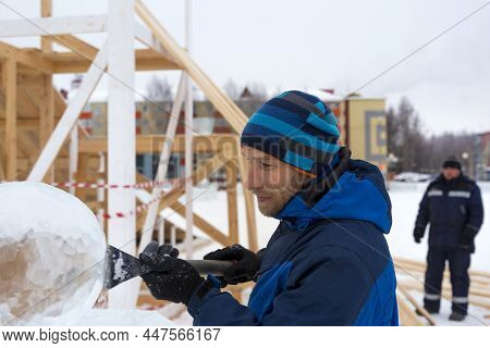 Portrait Of A Sculptor In A Blue Winter Suit With A Chisel In His Hands At Work