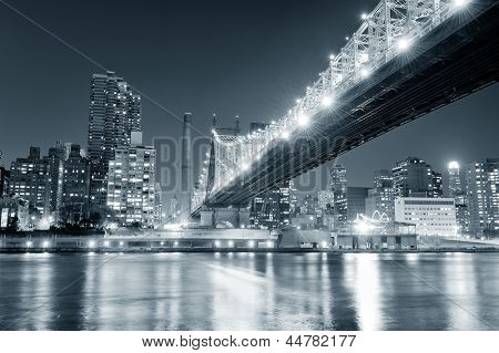 Ponte di Queensboro sopra New York City East River in bianco e nero di notte con riflessioni di fiume e 