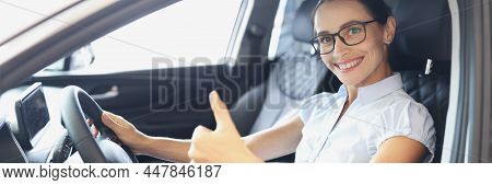 Portrait Of Smiling Woman Driving New Car Shows Thumbs Up. Buying New Car Concept