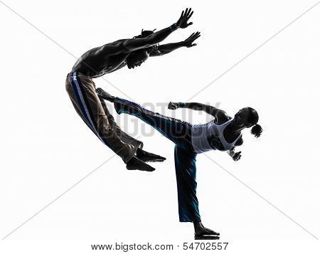 two people couple capoeira dancers dancing in silhouette studio isolated on white background