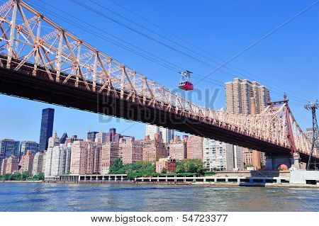Queensborough Bridge in Midtown Manhattan with New York City skyline over East River as the famous landmarks viewed from Brooklyn.