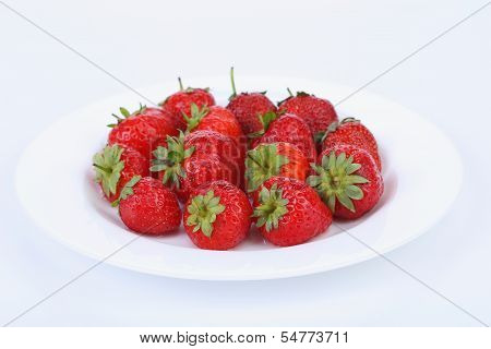 Fresh red ripe strawberries on a white plate