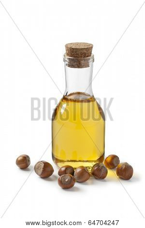 Hazelnut oil and hazelnuts on white background