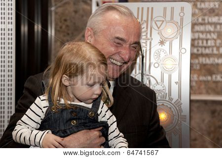 NEW YORK-APR 21, 2014: Police Commissioner William Bratton gets help from the daughter of an honored NYPD officer to light the Empire State Building in blue and purple for Police Memorial Week.