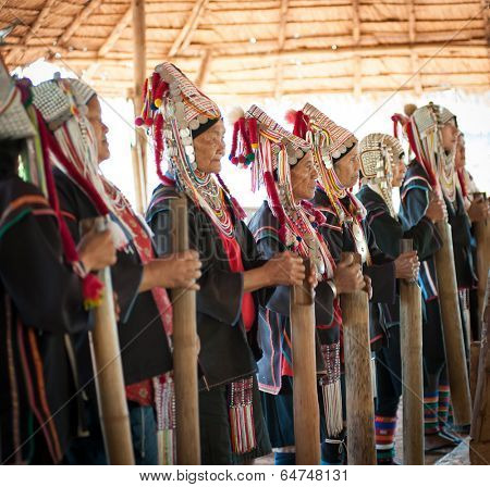 CHIANG RAI, THAILAND - DEC 4, 2013:Unidentified Akha hill tribe indigenous people dance in traditional clothes. Tourist travel tours to cultural villages are very popular. Folk costumes and jewelry