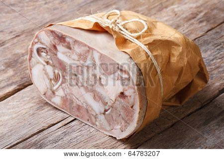 Headcheese Closeup On Table Tied With Twine And Wrapped In Paper