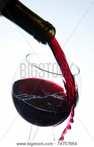 Red wine pouring into wine glass