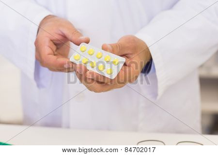 Pharmacist holding blister packs at the hospital pharmacy