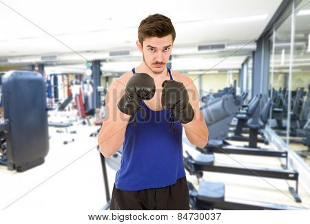Man with black boxing gloves at the gim