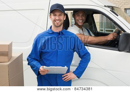 Delivery driver checking his list on clipboard with client outside the warehouse