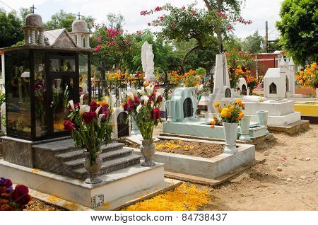 OAXACA,OAXACA,MEXICO- NOVEMBER 2, 2015: Tombs decorated with flowers in all saints day in Oaxaca, Mexico. All Saints Day is a Christian tradition that has been merged with the indigenous Mexican tradition of honoring the spirits with a graveside vigil.