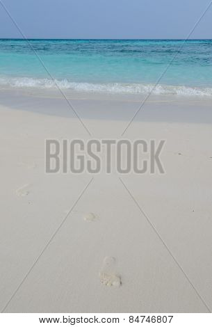 White Sand Beach And Crystal Clear Water With Footprint