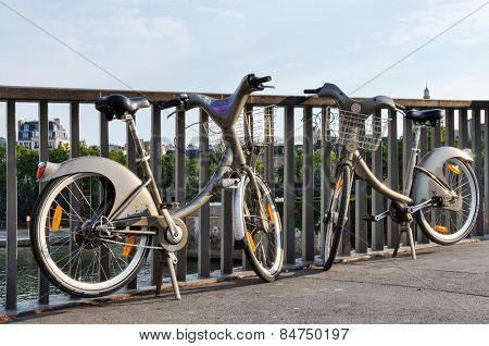 PARIS, FRANCE - CIRCA AUGUST 2009: Two Velib' on a bridge on the river Seine. Velib' is a public bicycle sharing scheme