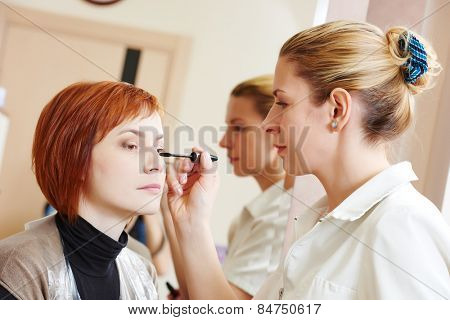 Makeup technique. mascara eyelashes of redheaded woman in beauty salon