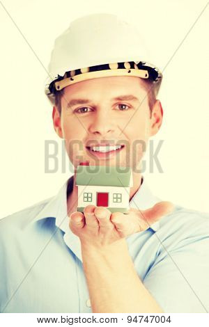 A forewoman holding a model house in hand