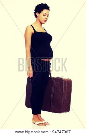 Sad pregnant woman with a lugagge