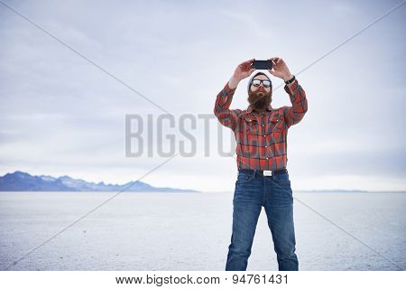 lone lumbersexual hipster taking selfie in salt flats