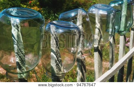 Glass Jars On A Fence.
