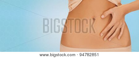 health, digestion, beauty, people and weigh loss concept - close up of woman pointing finger to belly over blue background