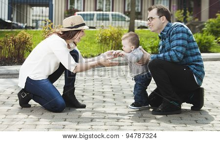 Happy Young Family Walking In The Park.