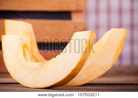 Photo slice ripe cut pumpkin on wood desk. Food background