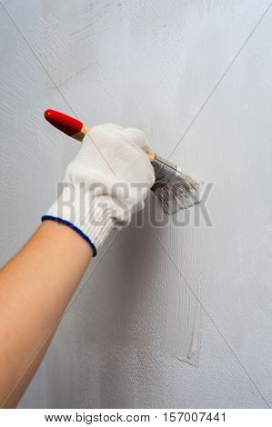Housepainter decorating wall with paintbrush. female hand holding brush.