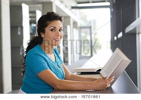 Giovane donna leggendo un libro a scuola