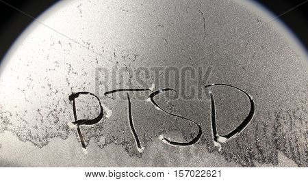 picture of a PTSD concept word on frosty window background