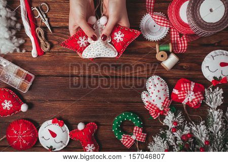 felt Christmas decorations on the wooden table - woman is preparing for handmade